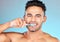 Face portrait, dental and man brushing teeth in studio isolated on a blue background. Wellness, oral health and routine