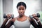 Face portrait, dumbbells and black woman training in gym for muscle, strength and power. Sports, energy and young female