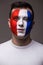 Face portrait of Pray France football fan in game of France national team look at camera.