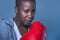 Face portrait of young angry and defiant black african American sport woman in boxing gloves training and posing as a dangerous f