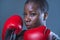 Face portrait of young angry and defiant black afro American sport woman in boxing gloves training and posing as a dangerous figh