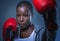 Face portrait of young angry and defiant black afro American sport woman in boxing gloves training and posing as a dangerous figh