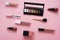 Face powder, brush and various cosmetic decorative makeup products on a color background. Close up. Makeup brush and