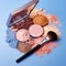 face powder, make-up brush and eye shadow palette isolated on blue background