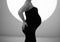 Without a face. A pregnant woman in a black tight dress.