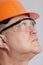 Face profile of thoughtful plump engineer in protective glasses, construction worker in hard hat onstudio background