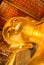 The face of reclined buddha gold statue in Phra Chettuphon Wimon Mangkhalaram Ratchaworamahawihan temple or Thai temple.