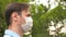 Face shield on young man outdoors in park. a man goes to work in city in medical mask. man tourist protecting face from