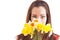 Face of a shy and introverted beautiful young woman hiding behind a bunch of daffodils and smelling