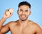 Face, skincare and orange with a man model in studio on a blue background to promote natural beauty. Portrait, fruit and