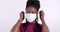 Face, smile and black woman take off mask for end of pandemic and safety isolated on a pink studio background. Happy