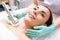 Face of smiling lady having oxygen meso therapy tool near her neck