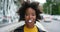 Face of a stylish, trendy and edgy black female with an afro eating gum and laughing downtown. Portrait of a young