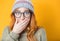 Face of surprised beautiful woman keeping hand on her mouth, isolated on yellow background. Head shot of amazing girl