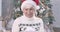 Face of surprised mature Caucasian woman holding Christmas gift box, looking at camera and smiling. Pleasant lady