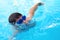 Face swimmer athlete in glasses closeup in drops of water. Little boy athlete swims in the pool by the crawl. The