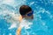 Face swimmer athlete in glasses closeup in drops of water. Little boy athlete swims in the pool by the crawl. The concept of sport