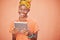 Face, tablet and black woman on social media in studio on an orange mockup background. Tech, smile and happy female from