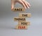Face the things you fear symbol. Wooden blocks with words Face the things you fear. Beautiful grey background. Businessman hand.