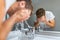 Face wash man splashing water cleaning washing face with facial soap in bathroom sink. Men taking care of skin, morning