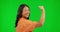 Face, woman and flex arm on green screen in studio isolated on a background. Portrait, strong muscle and Asian person