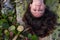 The face of a young beautiful girl lying upside down on a stone overgrown with green moss