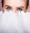 Face of young beautiful woman closed with white feathers