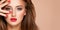 Face of young woman with red nails, lipstick and long brown hair.   Model with fashion makeup