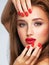 Face of young woman with red nails, lipstick and long brown hair.   Model with fashion makeup