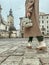 Faceless image of young stylish woman - travel blogger walking down the central city street holding a bouquet of autumn