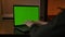 Faceless male typing something on green screen laptop keyboard