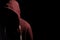 Faceless man in a hoody in dark shadows to disguise face