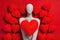 A faceless mannequin holding a large red heart close, surrounded by numerous heart shapes on a deep red background.