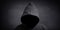 Faceless person wearing black hoodie hiding face in shadow
