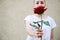 Faceless portrait of woman holding red rose in hand. Close-Up Of female Hands Holding Rose. Hipster woman hand holding a