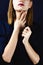 Faceless portrait of young adult white woman holding her hands with dark manicure on her neck