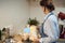 Faceless woman cooking and baking dough on kitchen table at home,