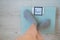 Faceless woman measures weight on the floor scales. Top view of women`s feet in gray socks on the scales with the word