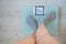 Faceless woman measures weight on the floor scales. Top view of women`s feet in gray socks on the scales with the word