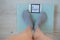 Faceless woman measures weight on the floor scales. Top view of women`s feet in gray socks on the scales with the word