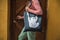 Faceless woman posing against wooden door with bear tote bag on the shoulder