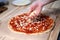 Faceless woman topping Rustic Italian homemade Pizza Dough margherita. Homemade food