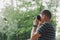 Faceless young man with ablack camera who takes pictures in the park