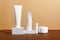 Facial and body care cosmetics bottles composition on brown background. Gel tube, lipstick, cream jar unbranded blank packages.