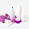 Facial body cosmetic products, lilac flowers blossom on white desktop background whith copy space. spring skin care layout.