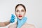 Facial cosmetic plastic surgery. Doctor surgeon hand in glove draw wrinkle lines on Woman face isolated white background.