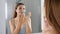 Facial hair removal. Panoramic banner of beautiful young woman shaving her face by razor at home. Pretty woman using shaver on