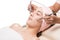 Facial massage,Peaceful brunette getting micro dermabrasion from beauty therapist