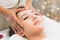 Facial massage in spa salon. Relaxation Beautiful woman lying on the bed and doing facial treatment in spa salon by masseur.