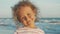 Facial portrait of beautiful little girl standing on the beach